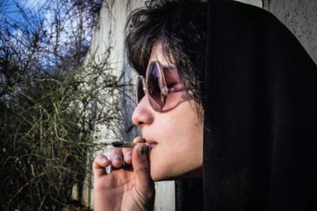 A young woman smokes marijuana on the hidden side of a park in Tehran in February, 2014. Photo: Barcroft