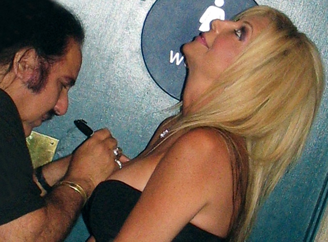 Pink Cross fraudster gets her surgically enhanced boobs signed by porn star Ron Jeremy